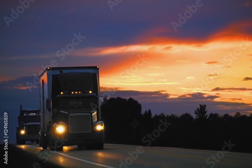 Semi Truck Driving At Sunset