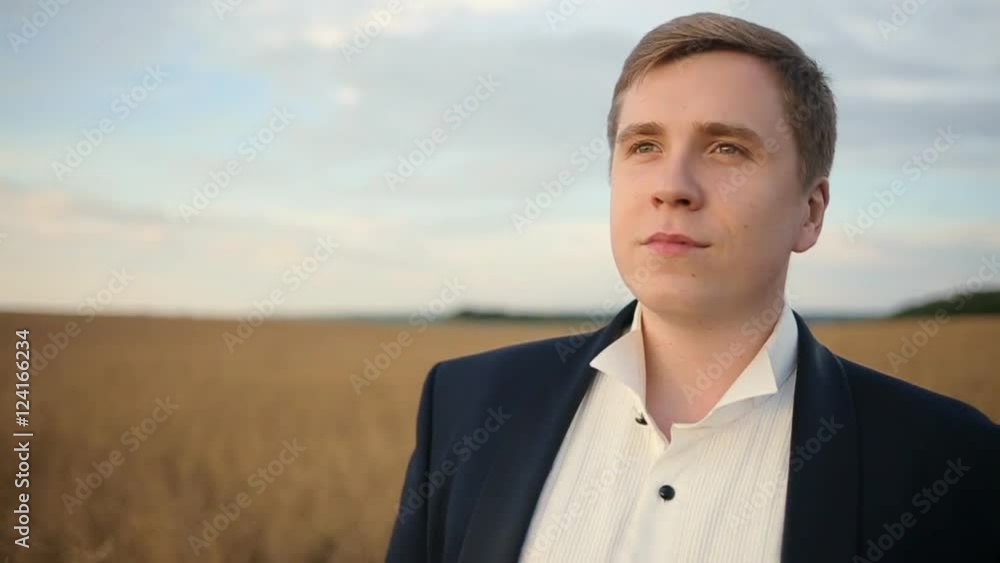Groom is walking at the wheat field