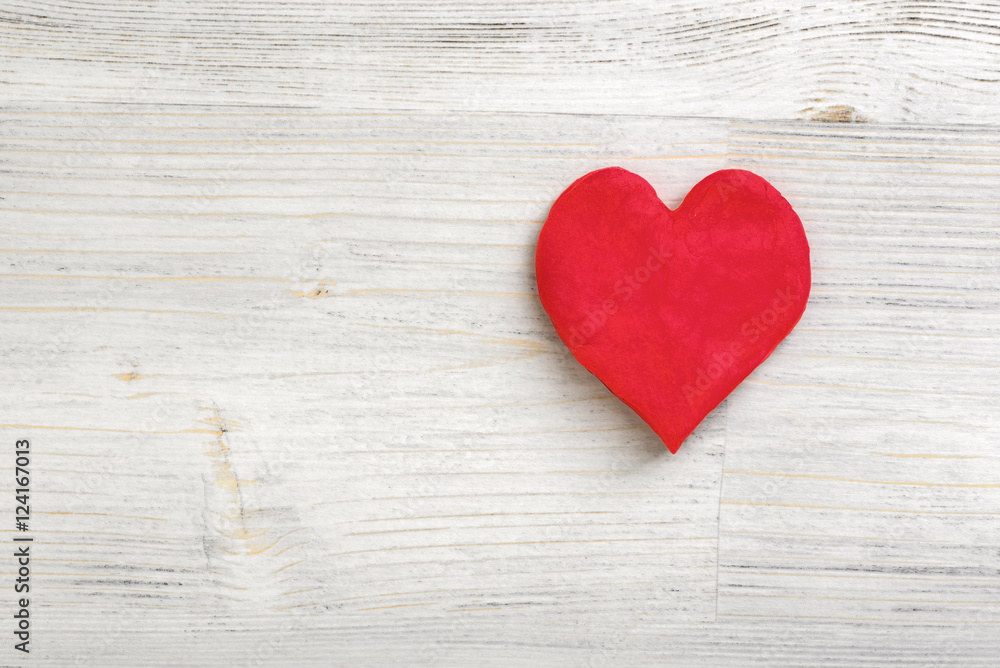 Plasticine little red heart laying on a light wooden surface Plasticine little red heart laying on a light wooden surface