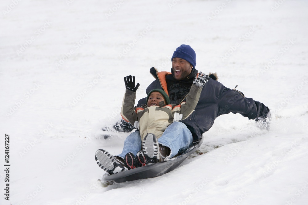 Father And Son Sledding On Snow