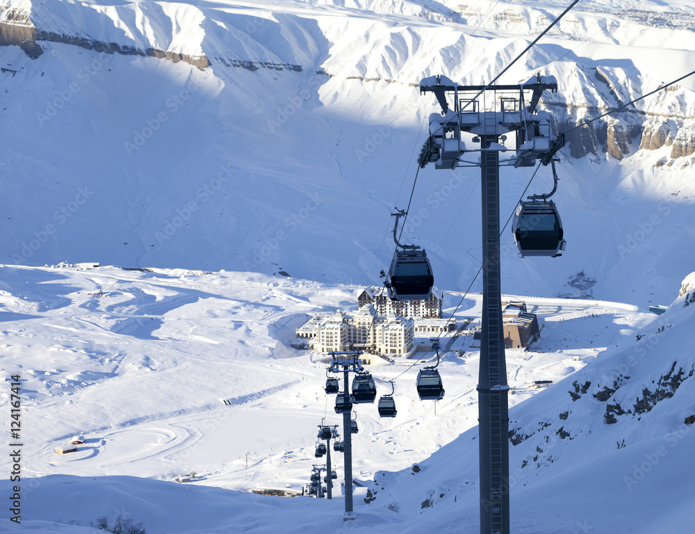 Obraz premium Gondola lift on ski resort at winter sun evening