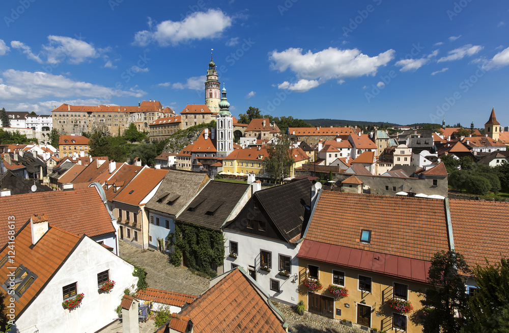 Panoramic view of Czech city Cesky Krumlov. European tile roof houses, a river and a bridge over it full of people in South Bohemian Region.