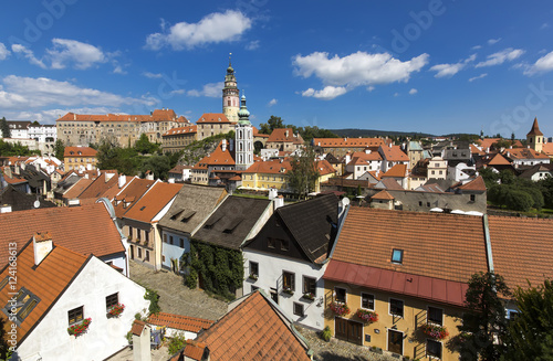 Panoramic view of Czech city Cesky Krumlov. European tile roof houses, a river and a bridge over it full of people in South Bohemian Region.