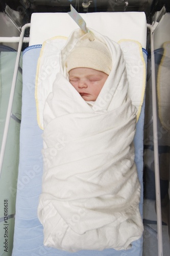 A Newborn Baby Wrapped In A Blanket Wearing A Cap In The Hospital; Millet, Alberta, Canada photo