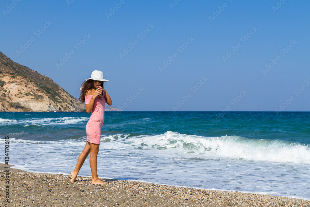 Beautiful carefree woman in short pink dress at the beach. Beautiful carefree woman in short pink dress at the beach.