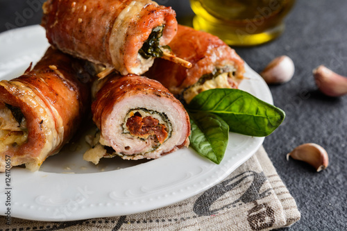 Pork cutlets wrapped in bacon and stuffed with cheese, spinach and sun dried tomato