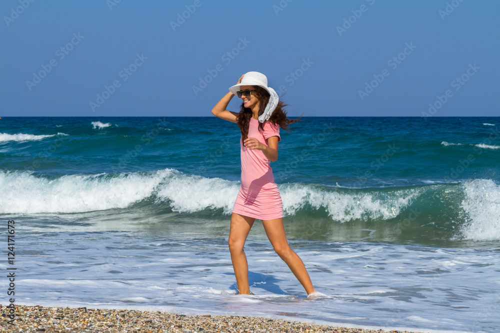 Beautiful carefree woman in short pink dress at the beach. Beautiful carefree woman in short pink dress at the beach.