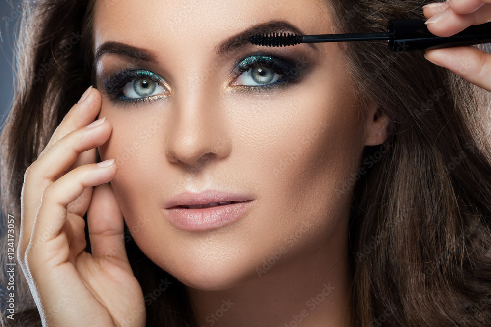 Beautiful woman applying mascara on her lashes Beautiful woman applying mascara on her lashes