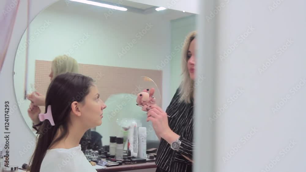 Reflection of make-up artist and model in the mirror Reflection of make-up artist and model in the mirror