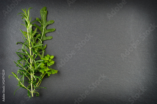 Rosemary, rocket and chervil herbs on slate