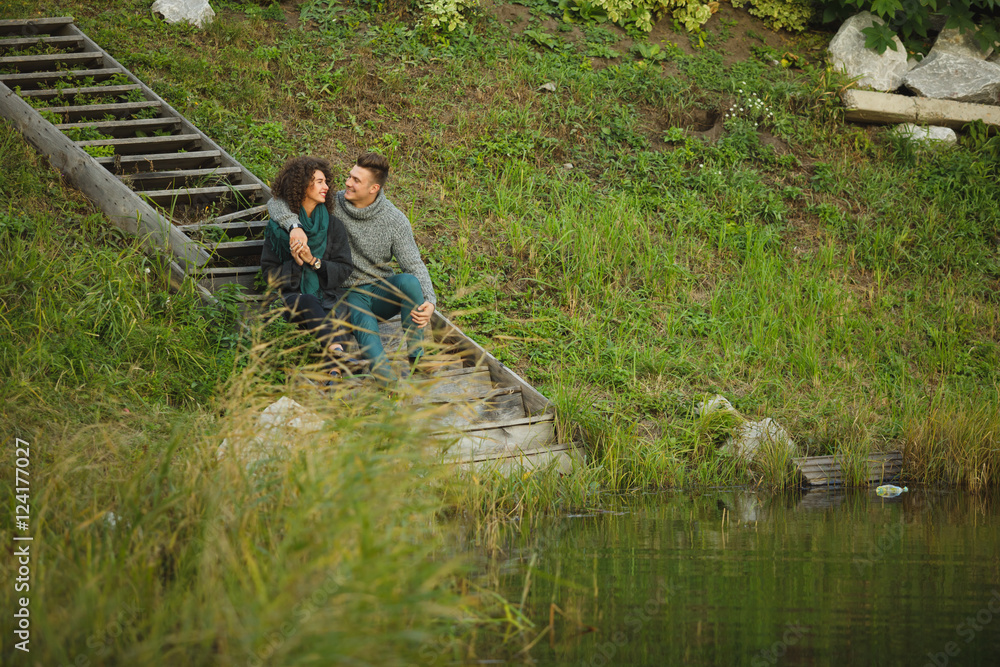 happy couple in love sitting on stairs entering a lake. happy couple in love sitting on stairs entering a lake.