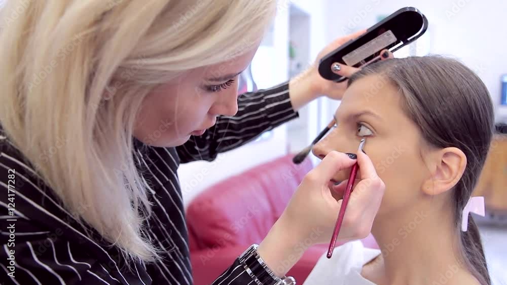 Close-up make-up artist puts a make-up eyes with eye shadow Close-up make-up artist puts a make-up eyes with eye shadow