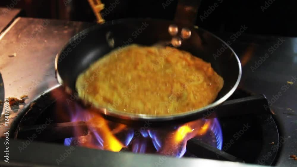 Chef prepares an omelette with chopsticks, closeup. Chef prepares an omelette with chopsticks, closeup.