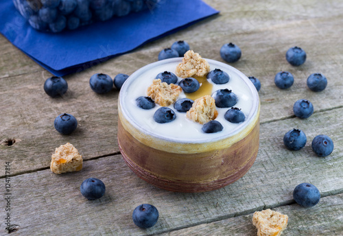 White yogurt with blueberries in ceramic bowl.