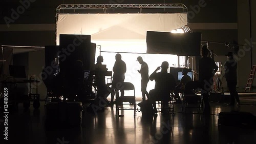 Unrecognizable film and photo crew working on professional studio shoot.