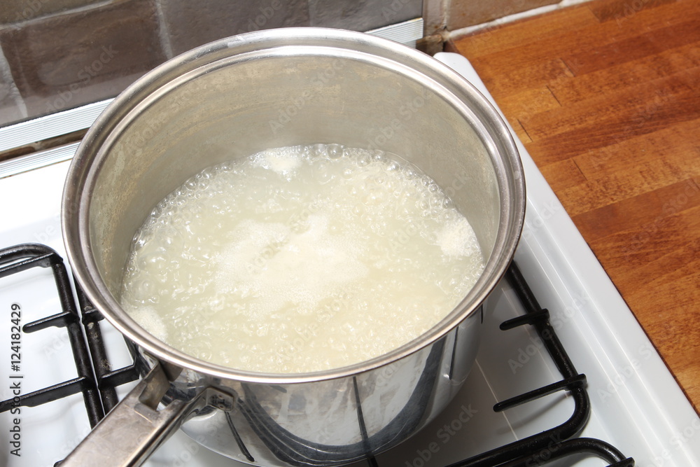 Sauce pan of rice in boiling water on a gas hob Sauce pan of rice in boiling water on a gas hob