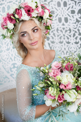 Gorgeous bride in wedding blue dress flowers wreath and bouqute photo