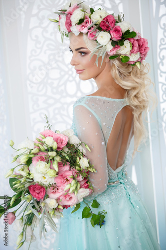 Gorgeous bride in wedding blue dress flowers wreath and bouqute