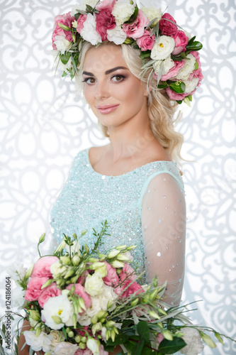 Gorgeous bride in wedding blue dress flowers wreath and bouqute photo