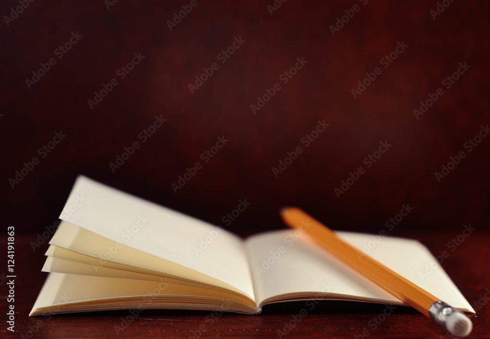 Open diary pocket book and pencil on brown vintage background Open diary pocket book and pencil on brown vintage background