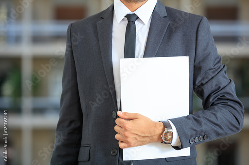 Man in suit holding documents