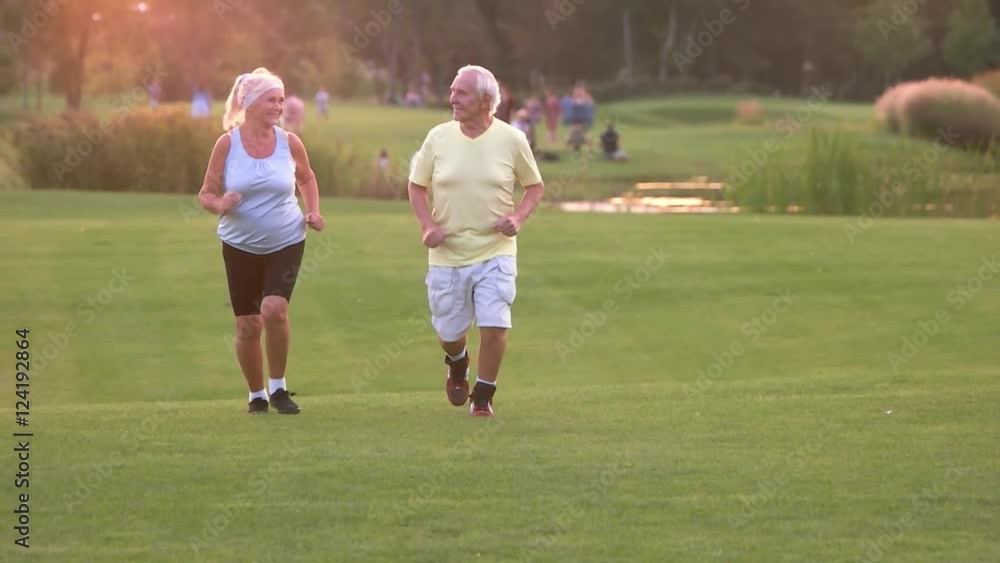 Senior couple running outdoors. Man and woman smiling. Active leisure of pensioners. Save your health. Senior couple running outdoors. Man and woman smiling. Active leisure of pensioners. Save your health.