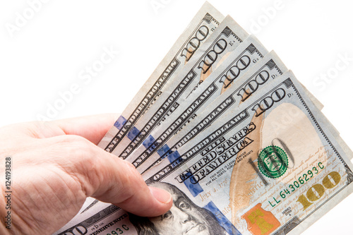 Five One hundred dollar bills being held in hand.