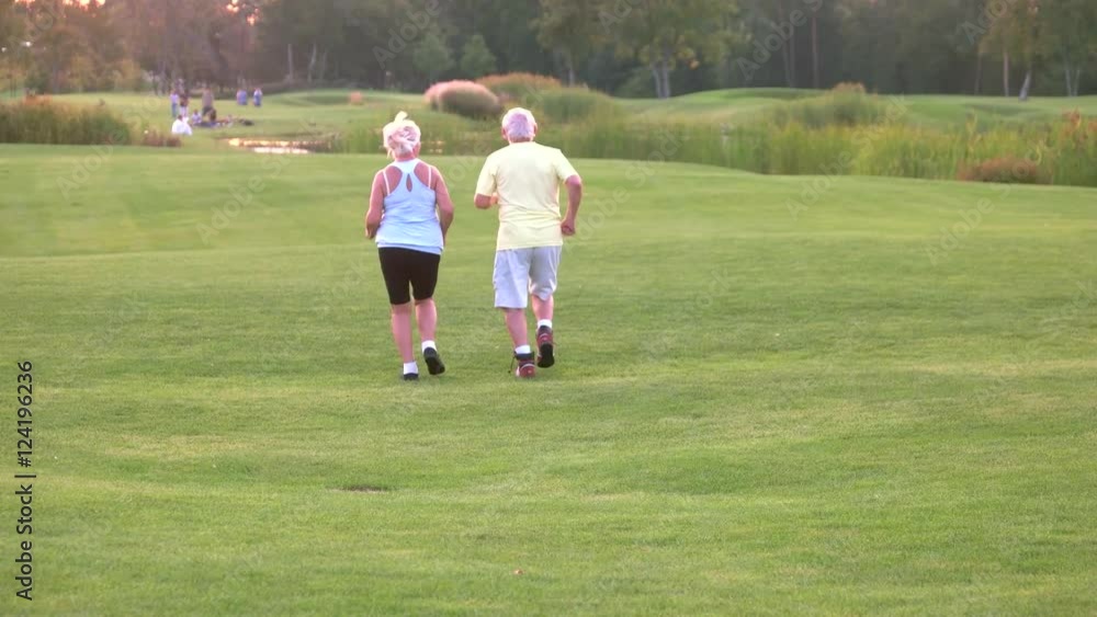 Senior couple is jogging. People running on grass. Health of respiratory system. Do cardio every day. Senior couple is jogging. People running on grass. Health of respiratory system. Do cardio every day.