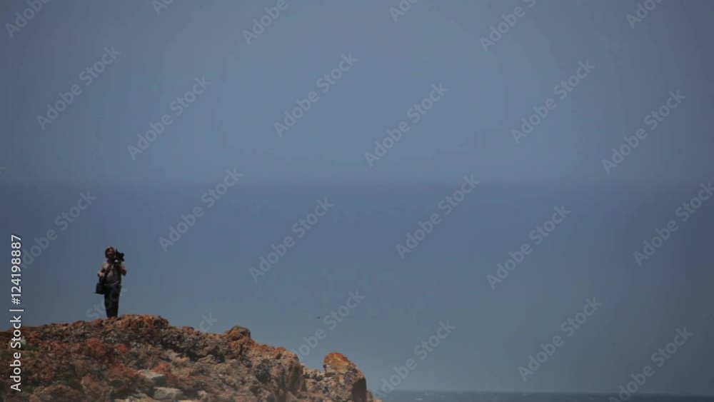 Photographer on cliff with camera in Knysna, South Africa. Photographer on cliff with camera in Knysna, South Africa.