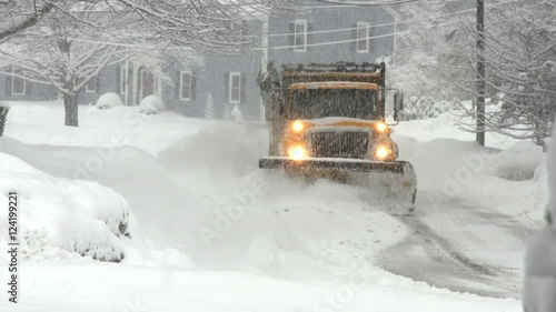 Wide shot of snowplow clearing street