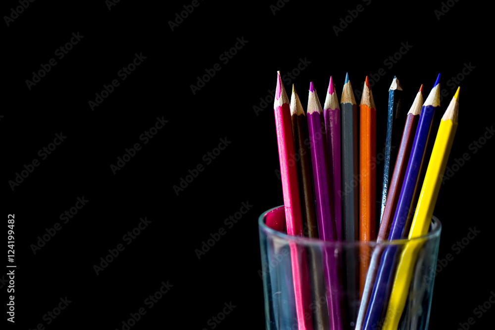 Fototapeta premium Color pencil on black background with copy space