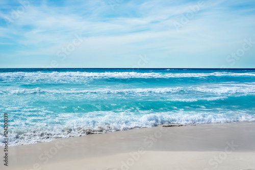 Sandy beach backdrop with stormy water and blue cloudy sky