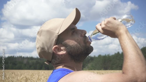  Man face closeup drinking water from bottle.  Sport fitness. photo