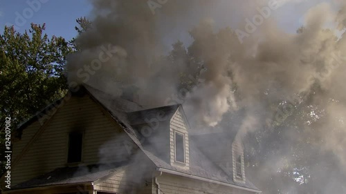 Wide shot of smoke coming out from burning house