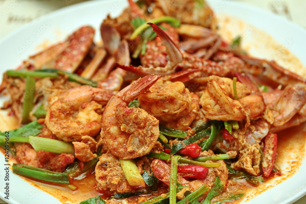 Close up of stir-fried crab and shrimp in curry powder is top-ten of popular Thai food as seafood to fried with fresh milk ,grill curry ,egg ,oyster oil and yellow curry power. Selective focus. Close up of stir-fried crab and shrimp in curry powder is top-ten of popular Thai food as seafood to fried with fresh milk ,grill curry ,egg ,oyster oil and yellow curry power. Selective focus.