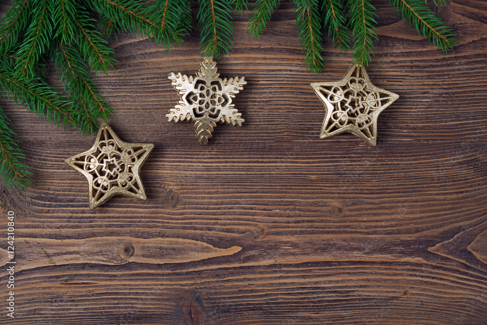 Christmas background with fir frame, golden stars and snowflakes, wooden background Christmas background with fir frame, golden stars and snowflakes, wooden background