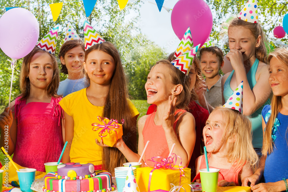 Group of excited kids congratulating birthday girl Group of excited kids congratulating birthday girl