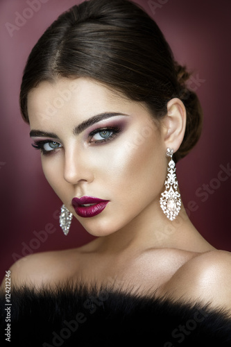 Beautiful woman portrait with glamour make up and shiny earrings.