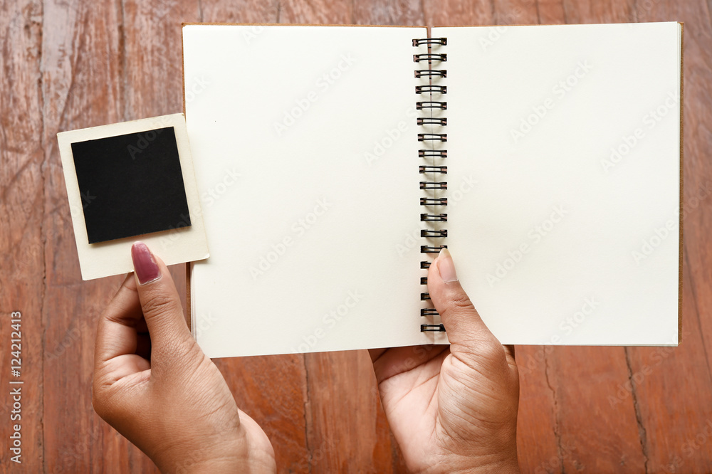 Obraz premium Blank notebook and photo frames on hand for background