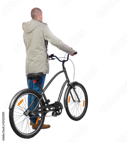 back view of a man with a bicycle. Cyclist in parka jacket keeps the wheel of a bicycle. Rear view people collection. backside view of person. Isolated over white background.