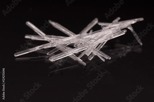 Tiny transparent crystals on black reflective background