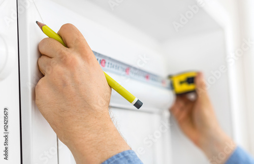Cuadro en lienzo Man installing cassette roller blinds on windows.