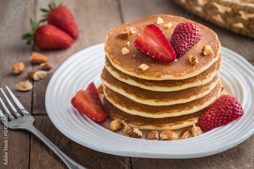 Pancakes with strawberry and almonds on plate