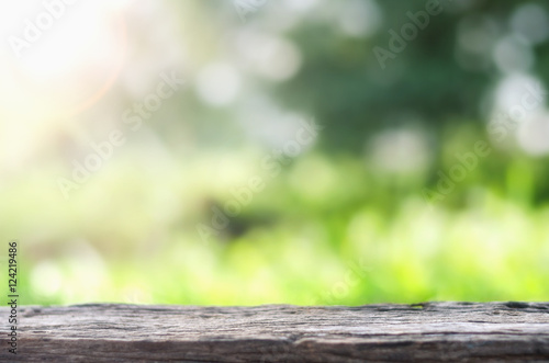Empty wooden deck table over blurred tree with bokeh background