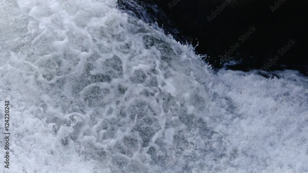 Slow motion tilt of water flowing on rocks Slow motion tilt of water flowing on rocks