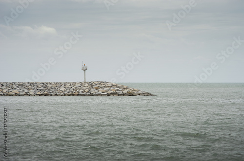 light tower at a pier among the sea.cloudy sky.selective focus