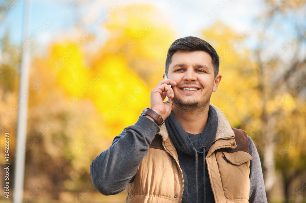 Smart handsome man talking on smartphone in park Smart handsome man talking on smartphone in park