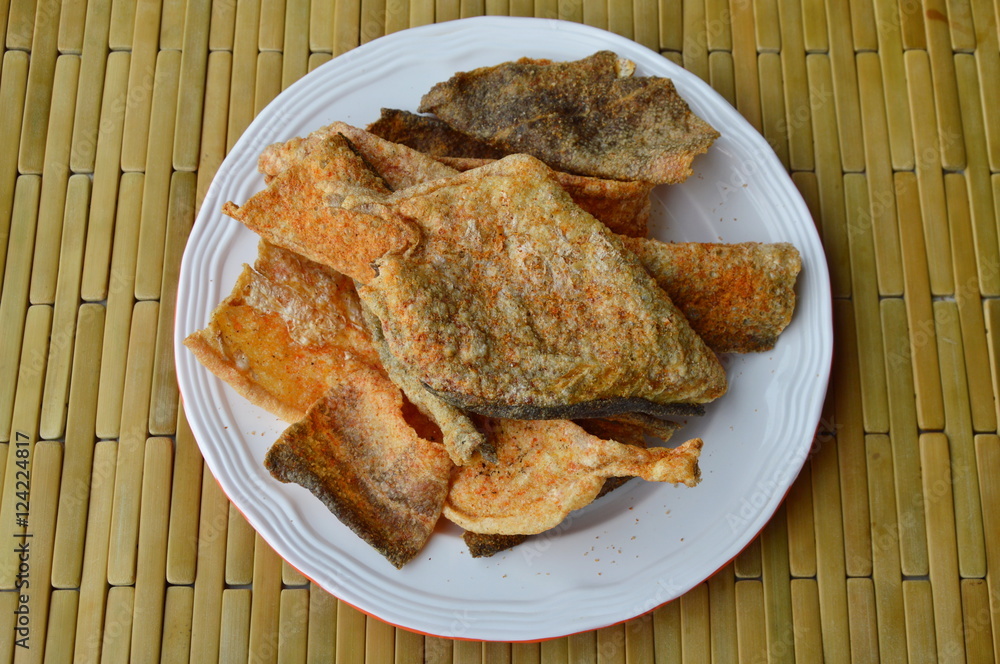 crispy fried fish skin with seasoning on dish crispy fried fish skin with seasoning on dish