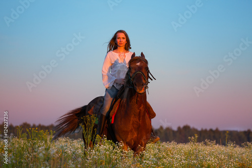 Portrait of beautiful woman riding horse at sunset