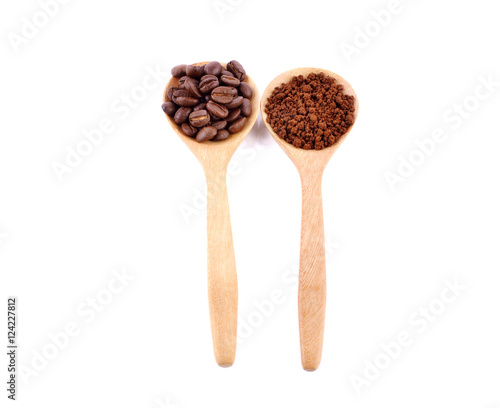 Coffee beans and ground coffee in a spoon.